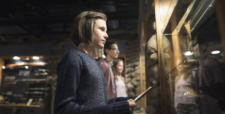 Een jeugdige museumbezoeker bekijkt aandachtig de vitrine
