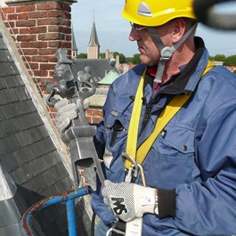 Monumentenwachter voert met een hoogwerker een inspectie uit aan de Abdij in Middelburg.