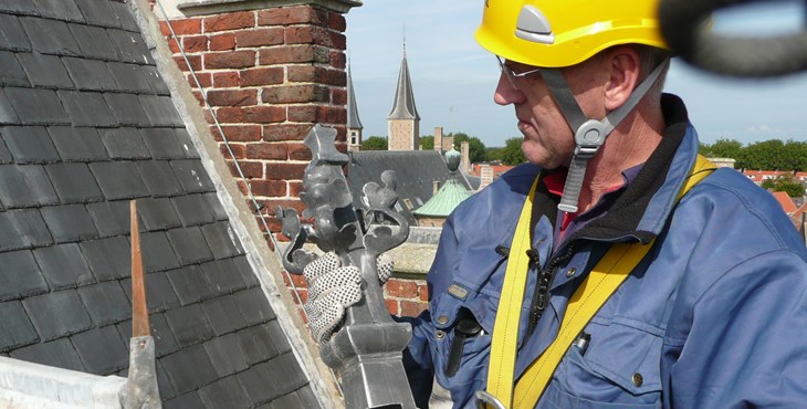 Monumentenwachter voert met een hoogwerker een inspectie uit aan de Abdij in Middelburg.