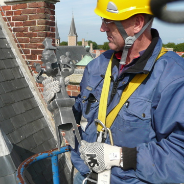 Monumentenwachter voert met een hoogwerker een inspectie uit aan de Abdij in Middelburg.