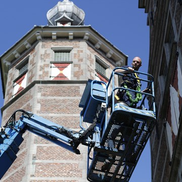 Monumentenwachter voert met een hoogwerker een inspectie uit aan de Kloveniersdoelen in Middelburg.