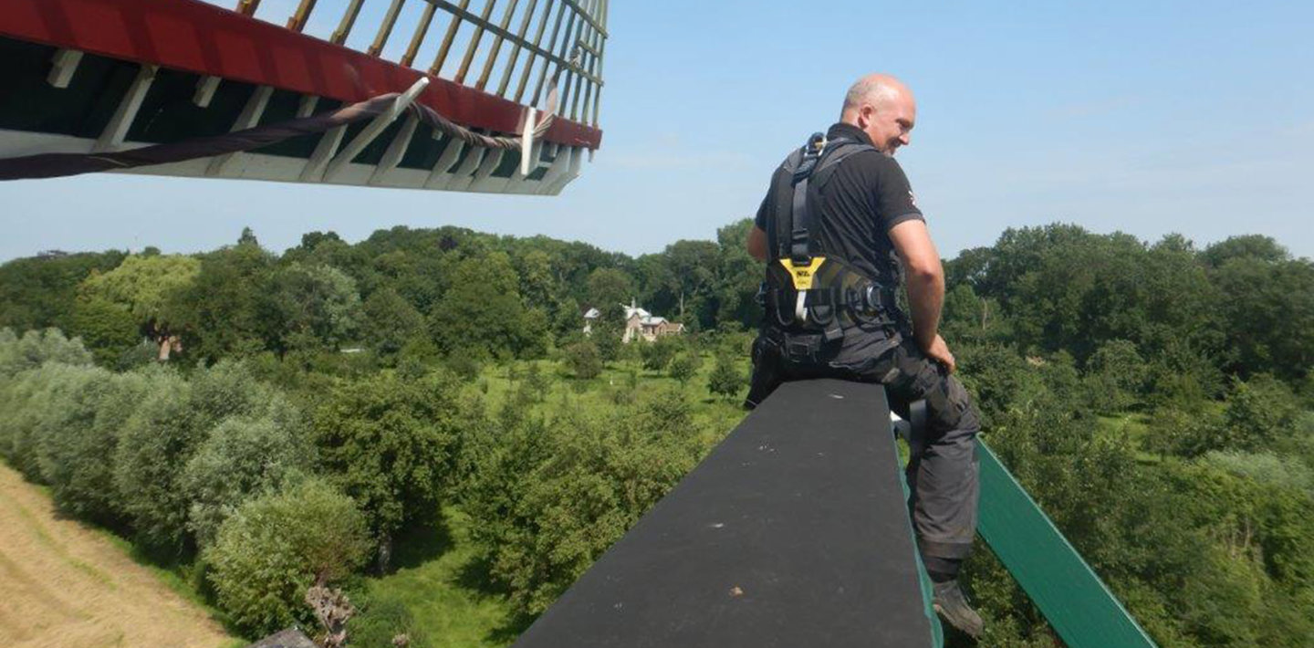 Monumentenwachter inspecteert Oostmolen in Kloetinge en kijkt uit over het landschap.