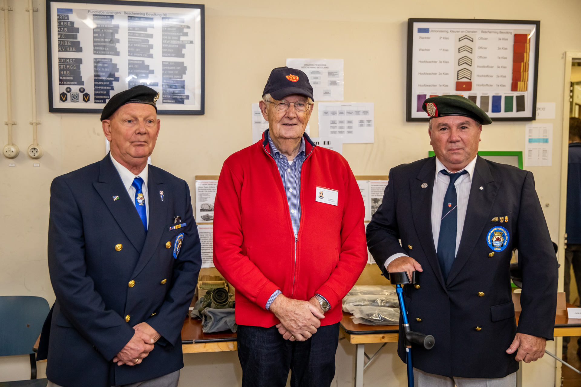 Vrijwilliger met twee oud werknemers in uniform van BB-dienst.