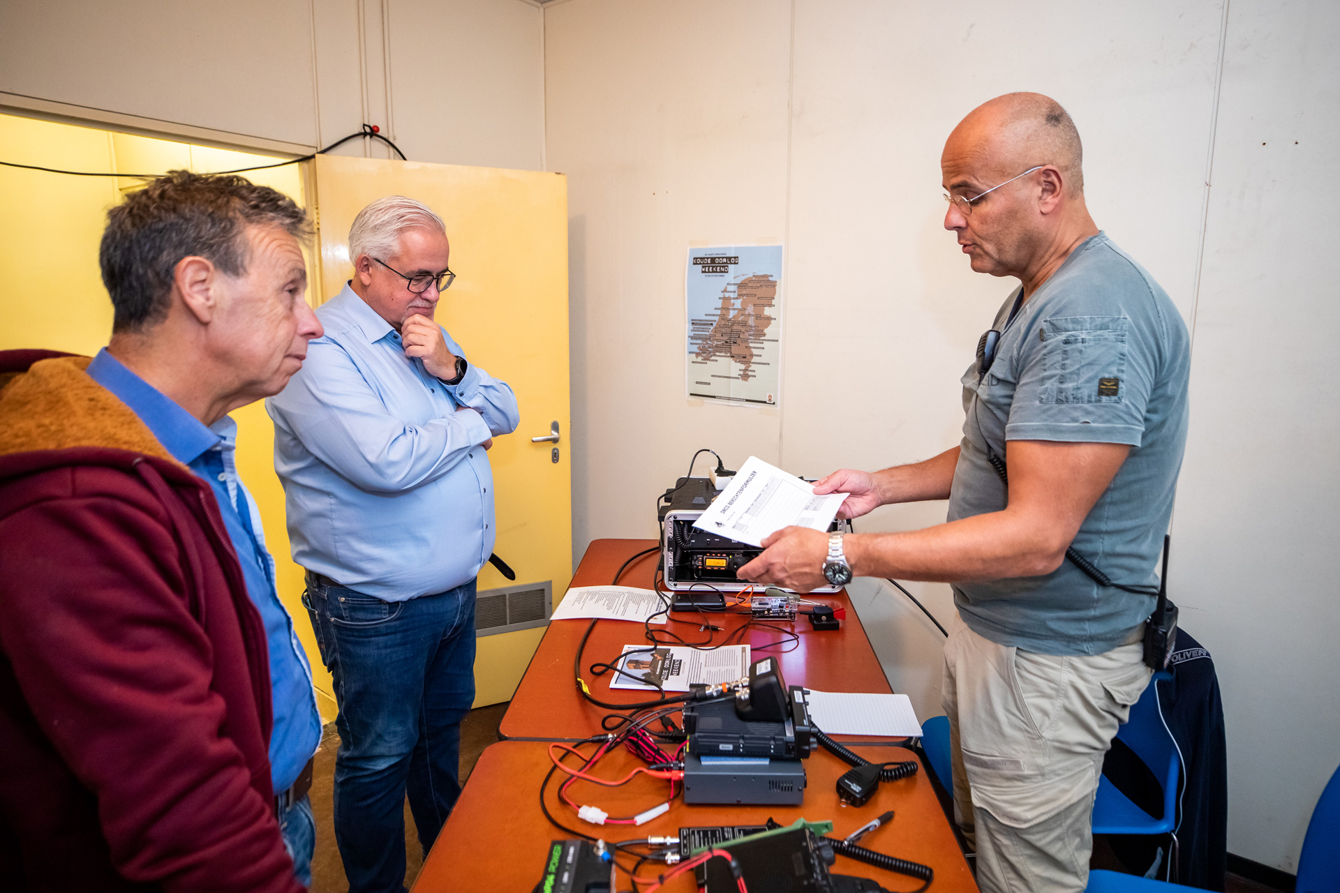 Twee mannen krijgen uitleg van vrijwilliger in BB-bunker.