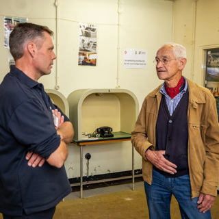 Twee mannen zijn in met elkaar in gesprek in de BB-bunker.