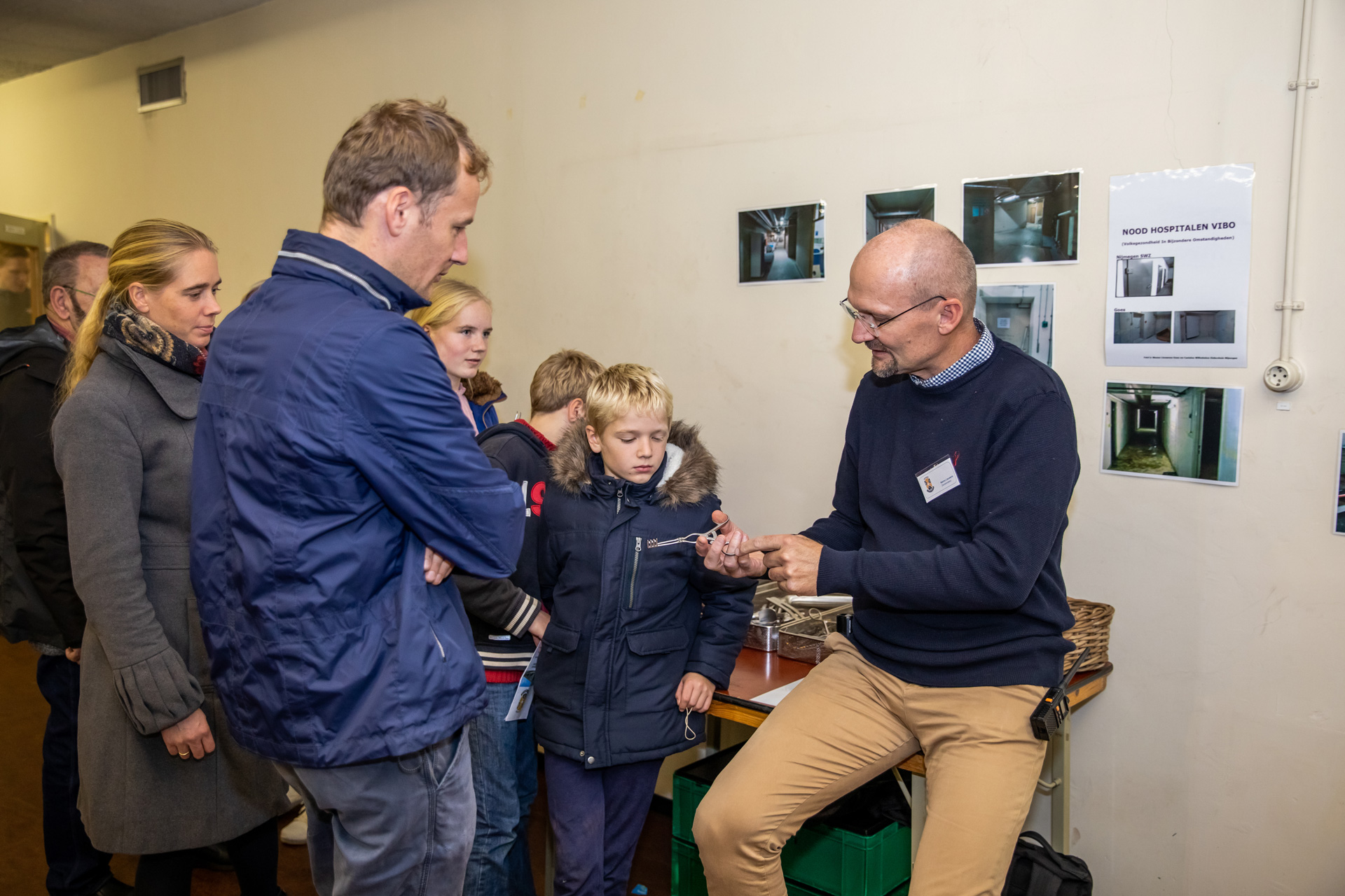 Vrijwilliger geeft uitleg over medische apparatuur aan kinderen en volwassenen in BB-bunker.