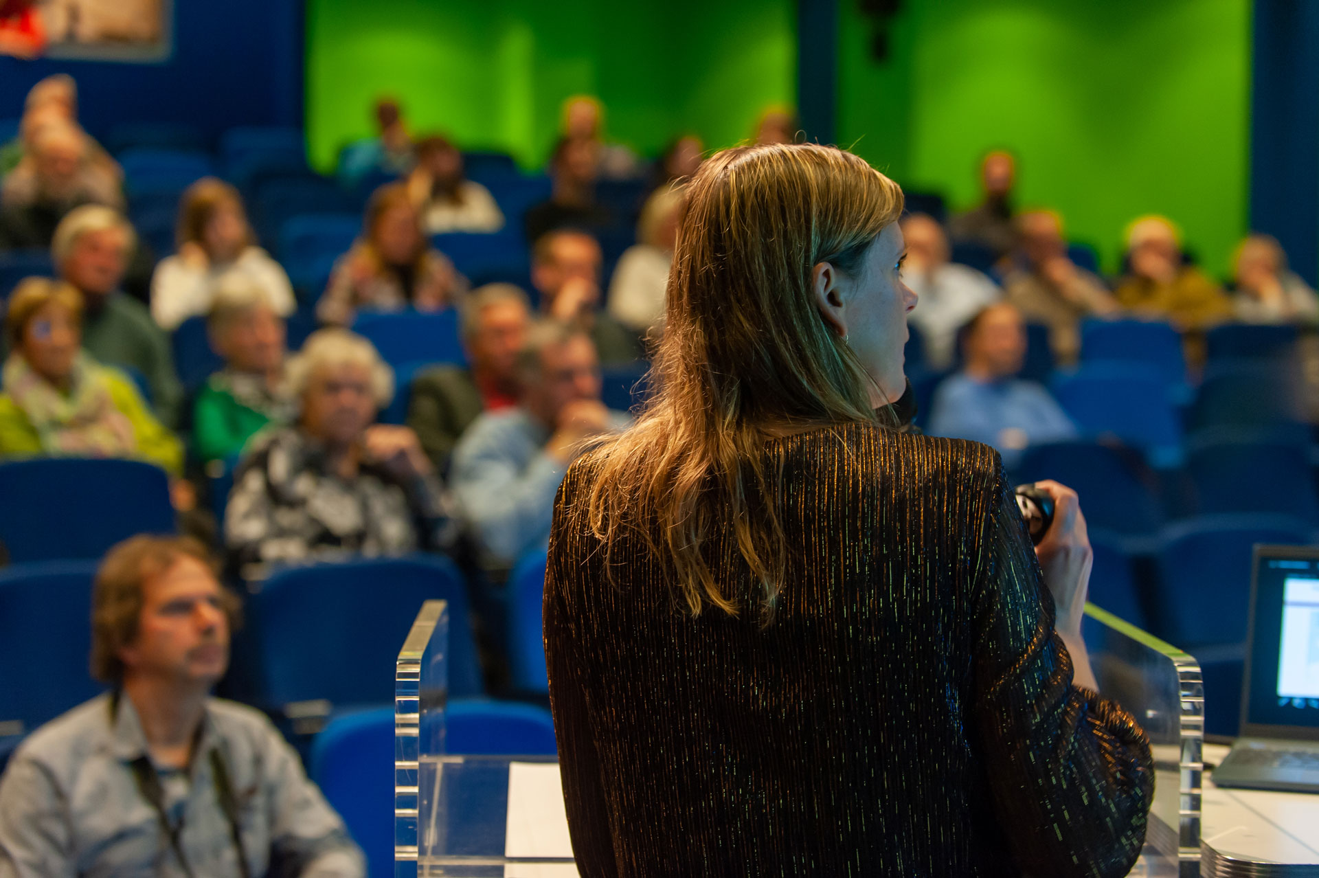 Juanita Kiburg tijdens haar lezing met op de achtergrond de deelnemer van de Zeeuwse Archeologiedag. 