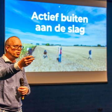 Alex Groosman, voorzitter AWN vertelt tijdens zijn lezing met Hans Jongepier over een mesolithische vindplaats bij Sint-Kruis.