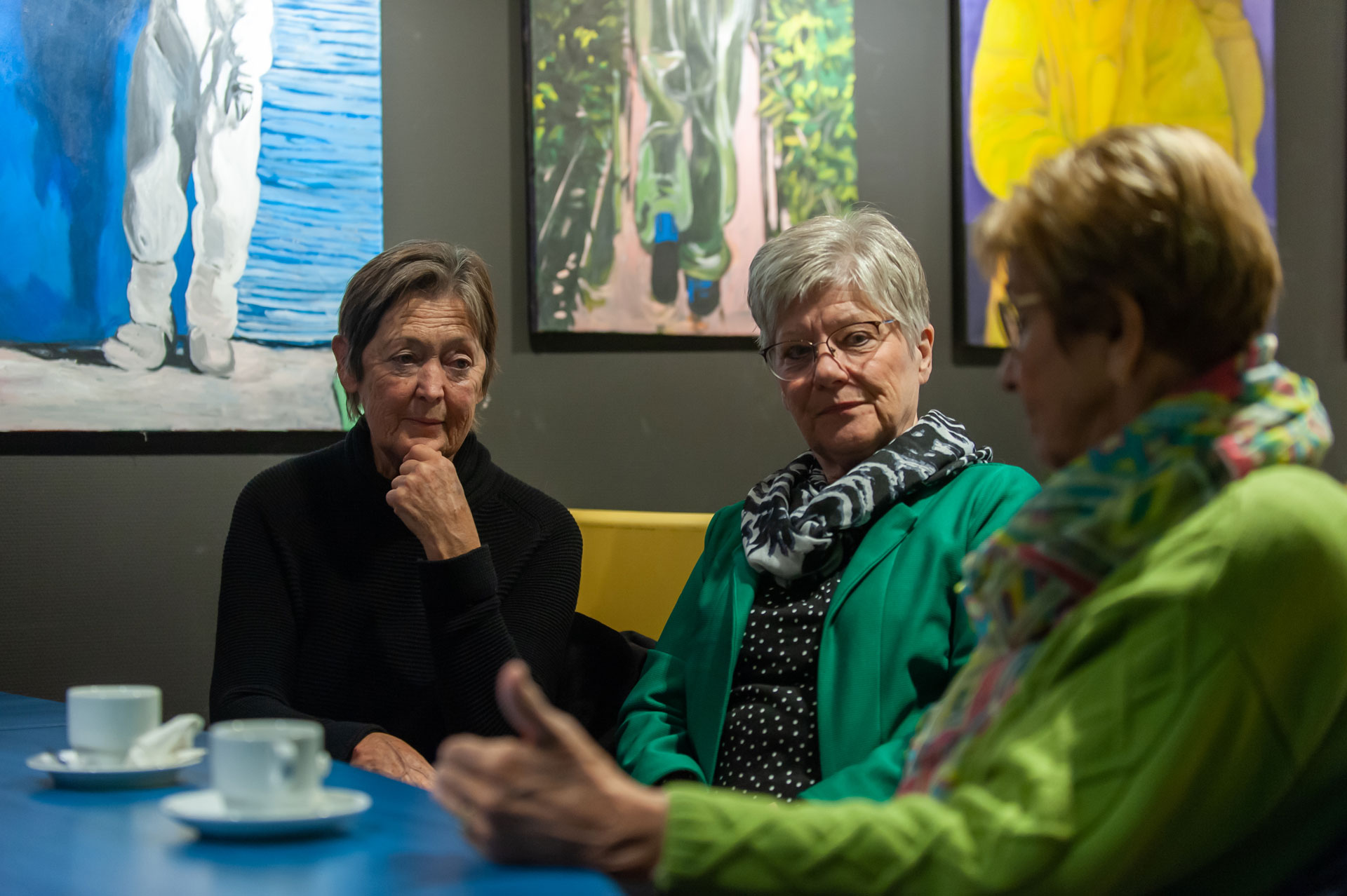 Drie deelneemsters drinken koffie aan tafel tijdens de Zeeuwse Archeologiedag. 