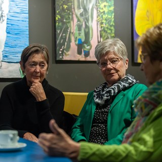 Drie deelneemsters drinken koffie aan tafel tijdens de Zeeuwse Archeologiedag. 