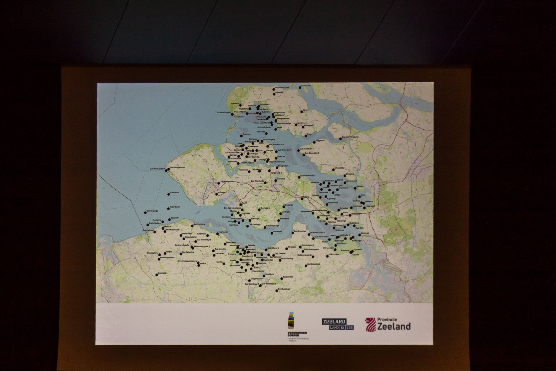 Close-up van de presentatie tijdens de lezing over verdronken dorpen met een kaart van Zeeland die aangeeft waar alle verdronken dorpen in Zeeland liggen. Foto Niek Beeke.