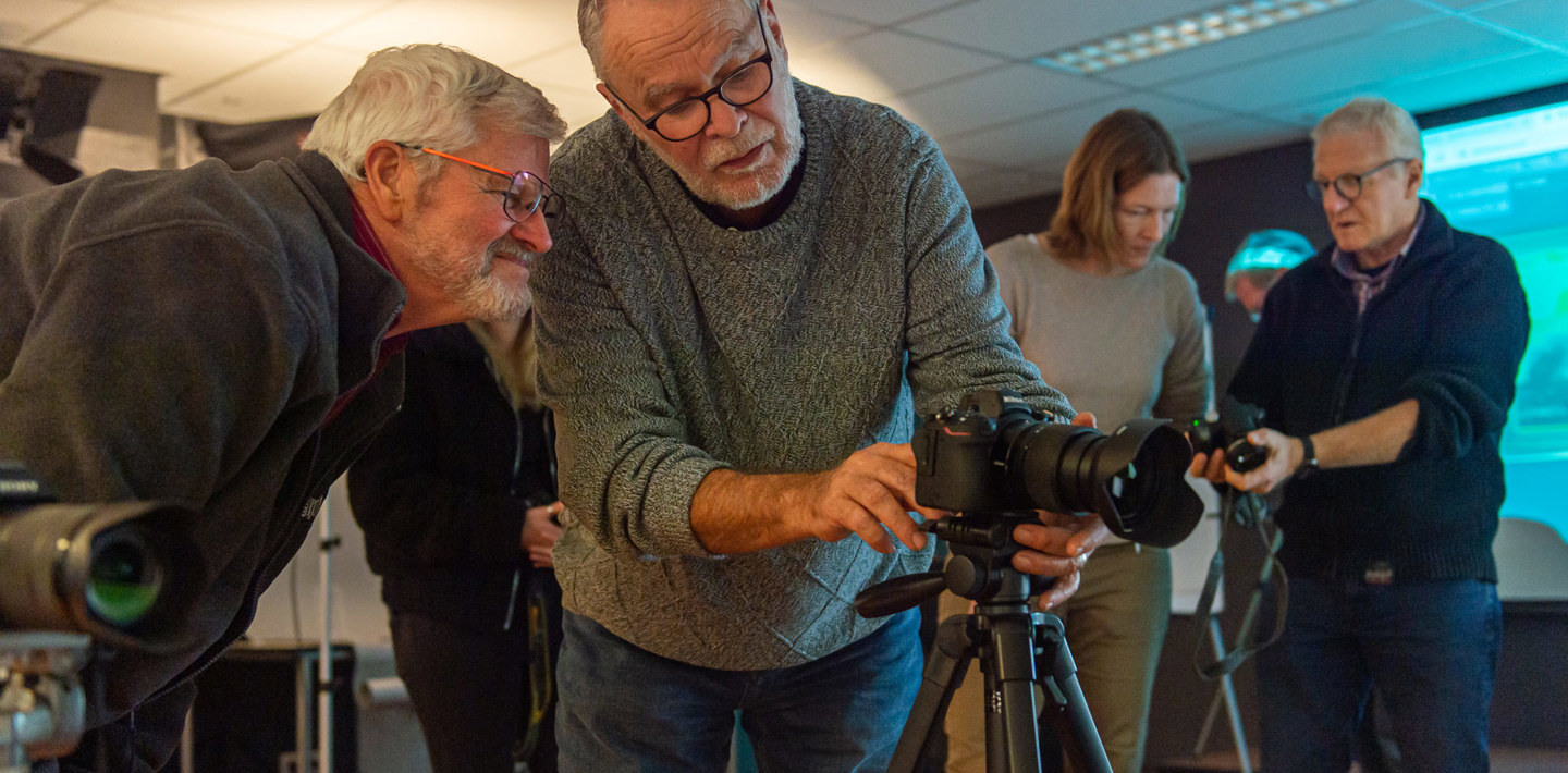 Een professionele fotograaf leert een museummedewerker de kneepjes van het vak.