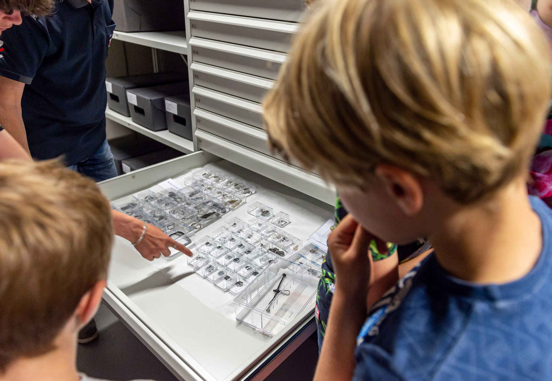 Een archeoloog van Erfgoed Zeeland laat archeologische metaalvondsten zien tijdens de rondleiding door het depot.