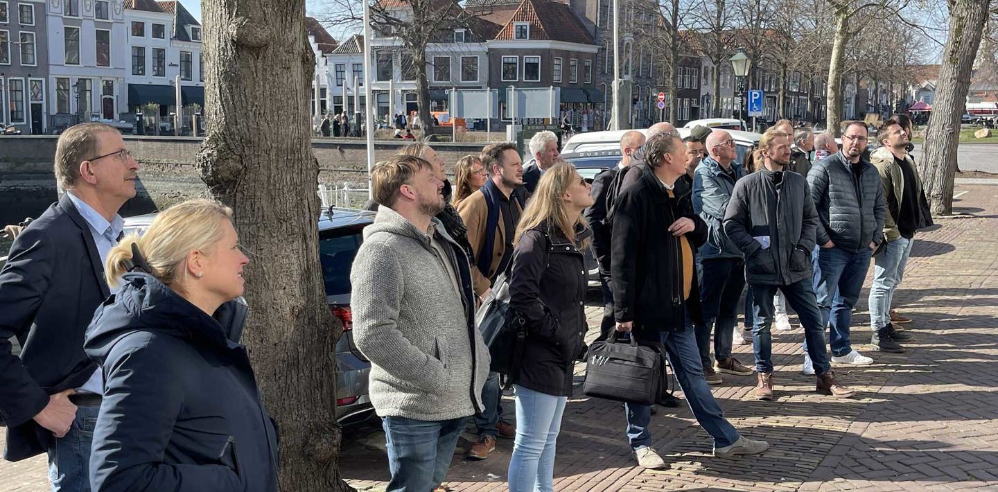 Beleidsmedewerkers worden staand voor een pand bijgeschoold over het vergunningenproces van monumenten.