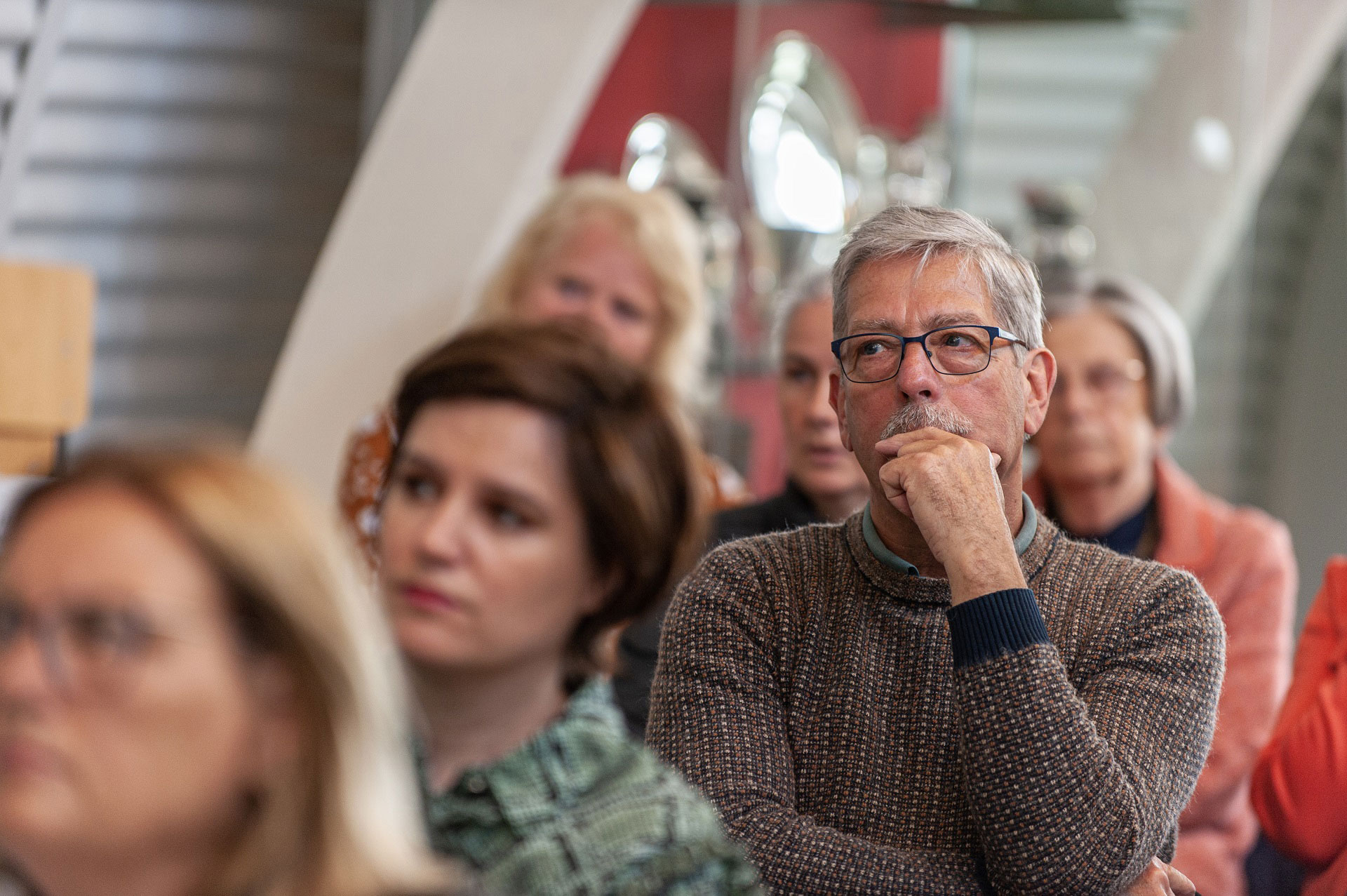 Aanwezigen van de voorjaarsbijeenkomst Reizen in de Tijd luisteren naar een spreker.