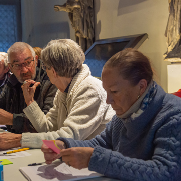 Afbeelding van vrijwilligers in overleg tijdens een cursus.