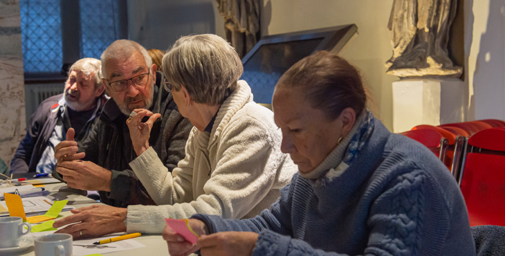 Afbeelding van vrijwilligers in overleg tijdens een cursus.