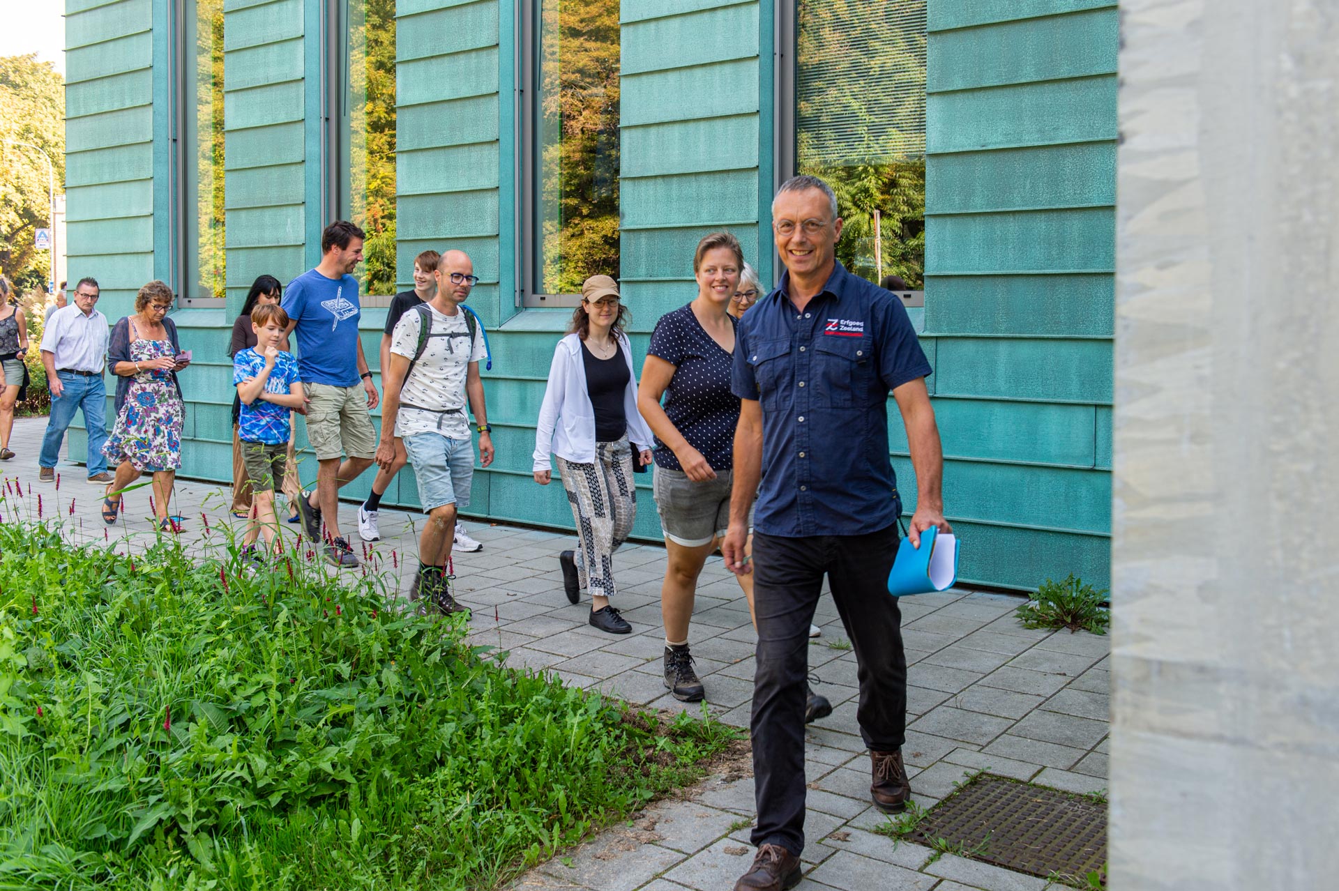 Bezoekers onder leiding van monumentenwachter Coert op weg naar de toegangsdeur  van de bunker aan de Looiersingel.