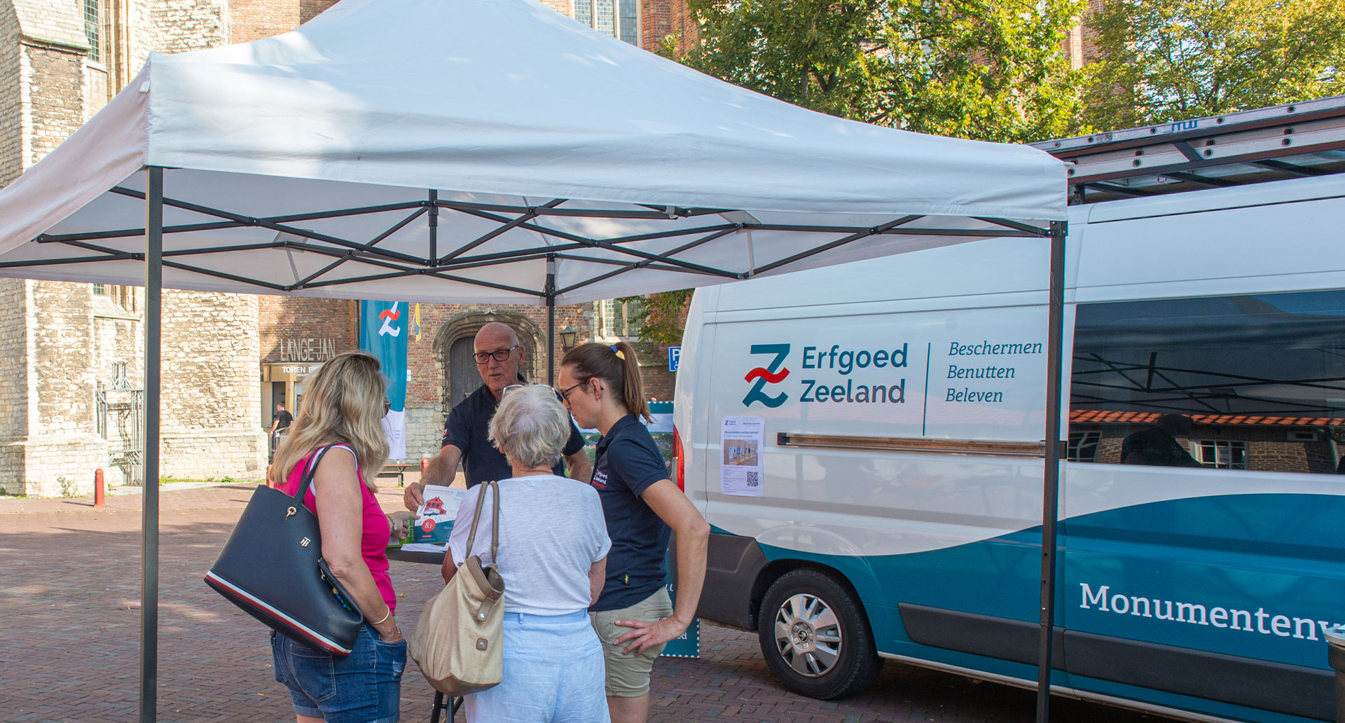 Op het Koorkerkplein in Middelburg staat de Monumentenwacht met infostand en bus tijdens open monumentenzaterdag.