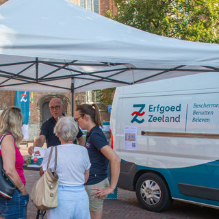 Op het Koorkerkplein in Middelburg staat de Monumentenwacht met infostand en bus tijdens open monumentenzaterdag.