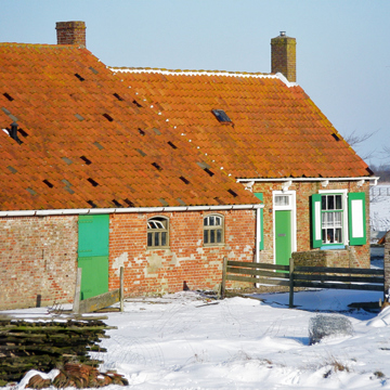 Historische boerderij in de sneeuw aan de Grindweg in Westkapelle