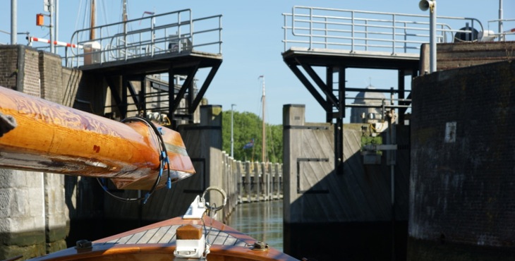 Oude zeilboot wachtend voor sluisdeuren