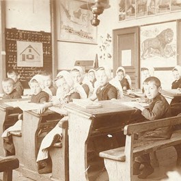 Een schoolklas in vroegere jaren met kinderen in klederdracht
