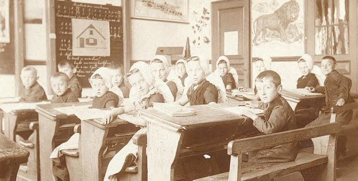Een schoolklas in vroegere jaren met kinderen in klederdracht