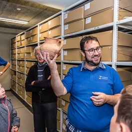 De depotbeheerder van Erfgoed Zeeland geeft een rondleiding door het depot tijdens de Open Dag in 2017. 