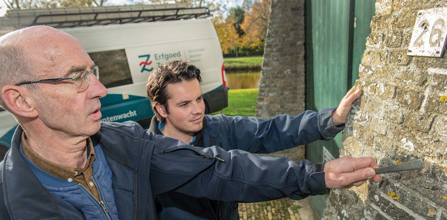 Twee monumentenwachters van Erfgoed Zeeland inspecteren een molen.