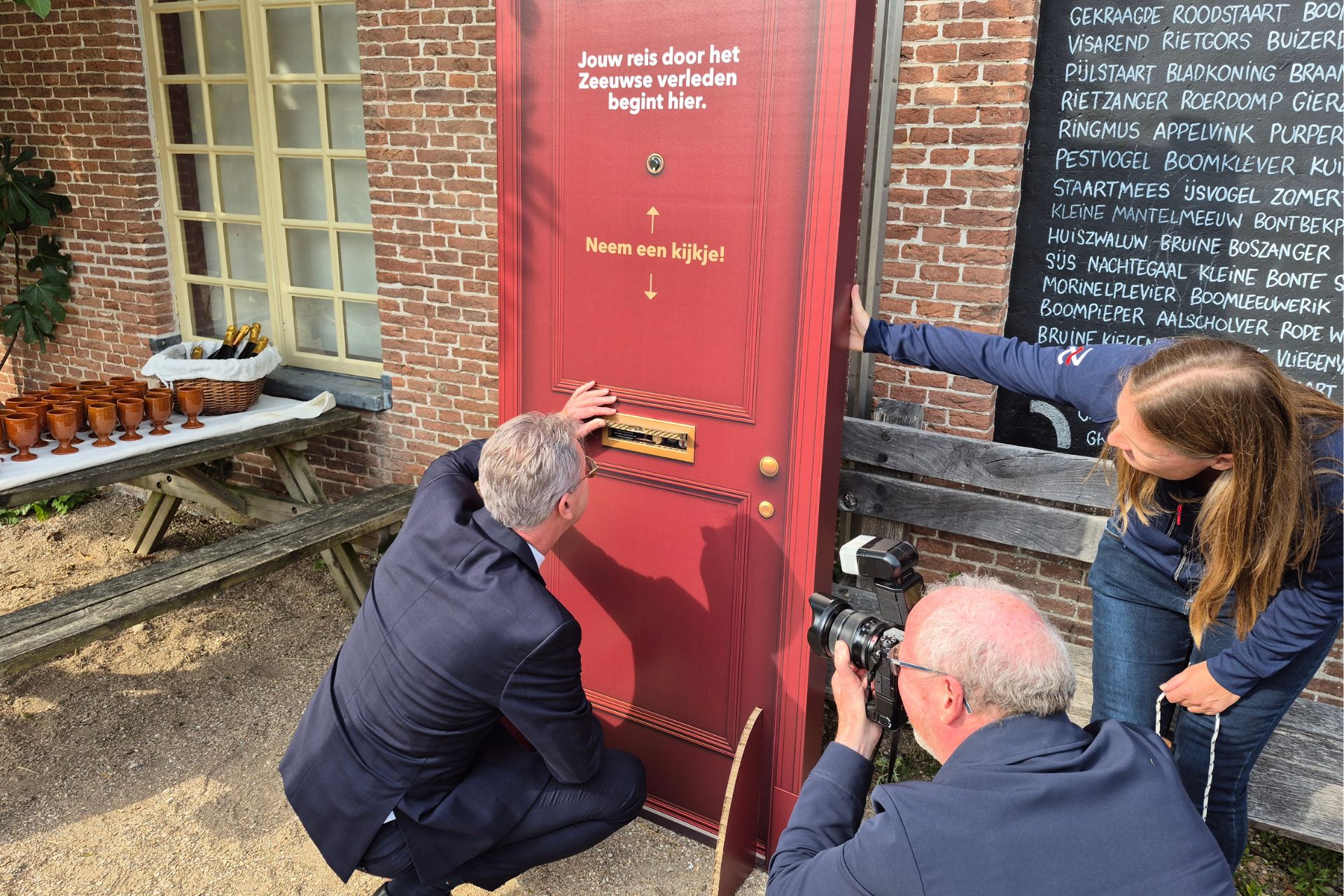 Gedeputeerde Harry van der Maas kijkt door de brievenbus naar een van de parels van Collectie Zeeland.