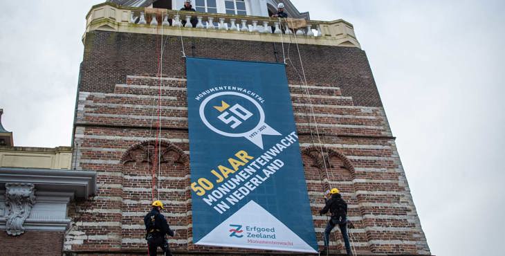 Monumentenwachters rollen de feestelijke banner 