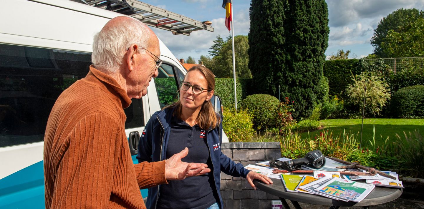 Met een bezoeker praten over verduurzaming bij de infostand van de Monumentenwacht tijdens Open Monumentendag.