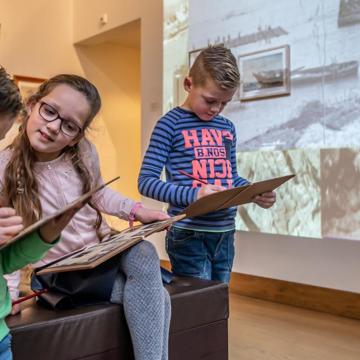 Drie kinderen doen een speurtocht in het Maritiem Muzeeum Zeeland.