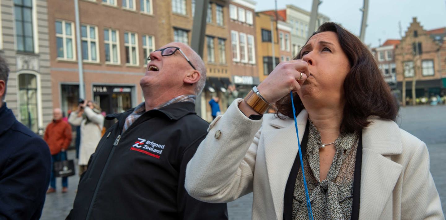 Gedeputeerde Anita Pijpelink luidt op 23 februari 2023 het 50-jarig jubileum van de Monumentenwacht in op de Grote Markt in Goes.