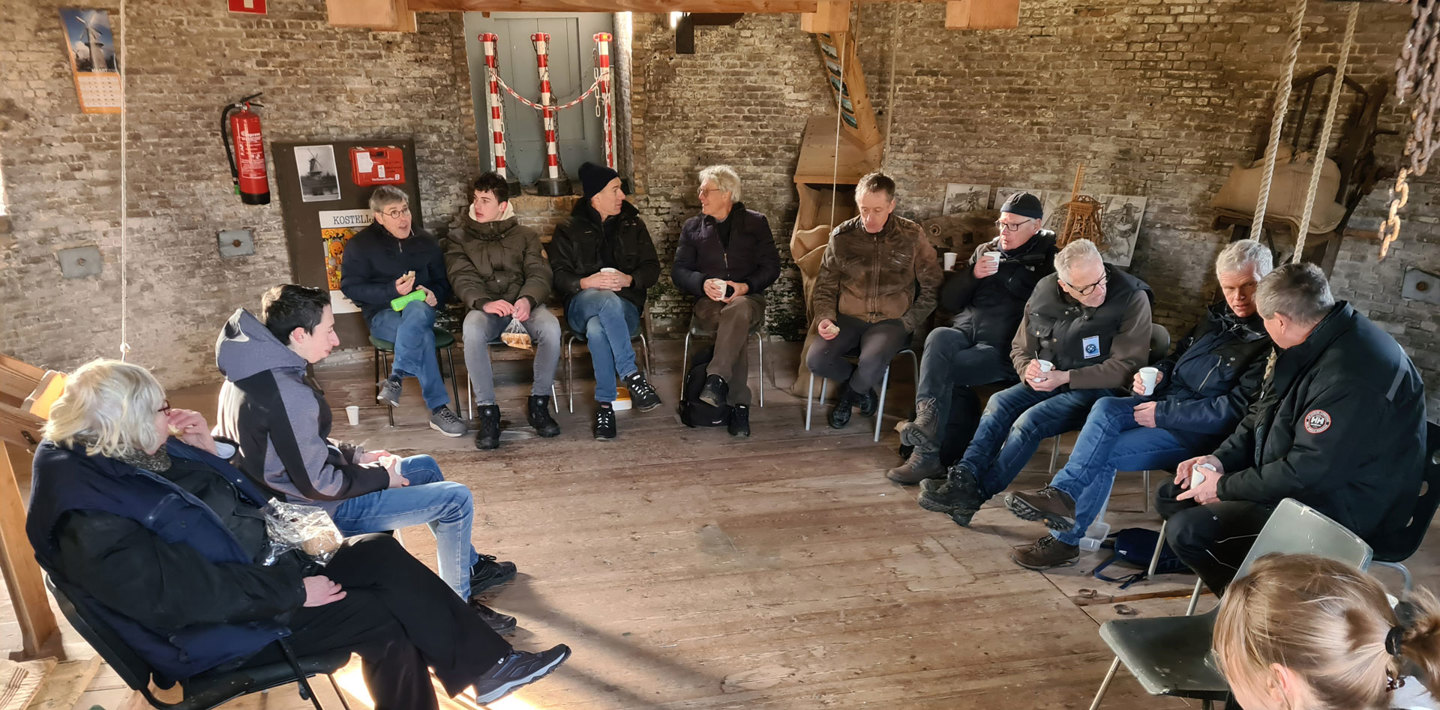 Een groep vrijwilligers in de molen van Kloosterzande tijdens een instructieles voor de opleiding tot molenaar.