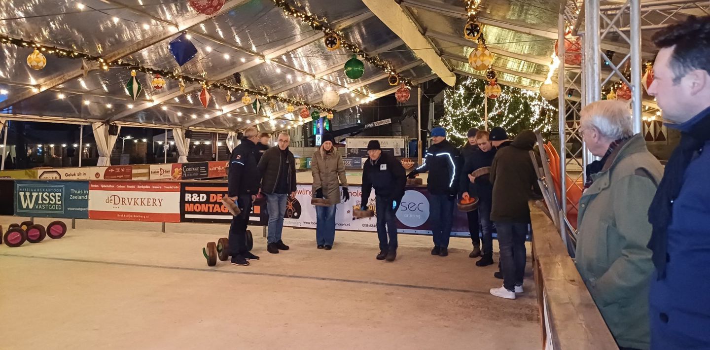Curlingcompetitie onder medewerkers van Erfgoed Zeeland op de ijsbaan op de Markt in Middelburg.