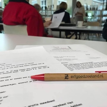 De pen van Erfgoed Zeeland en cursusmateriaal liggen op tafel.