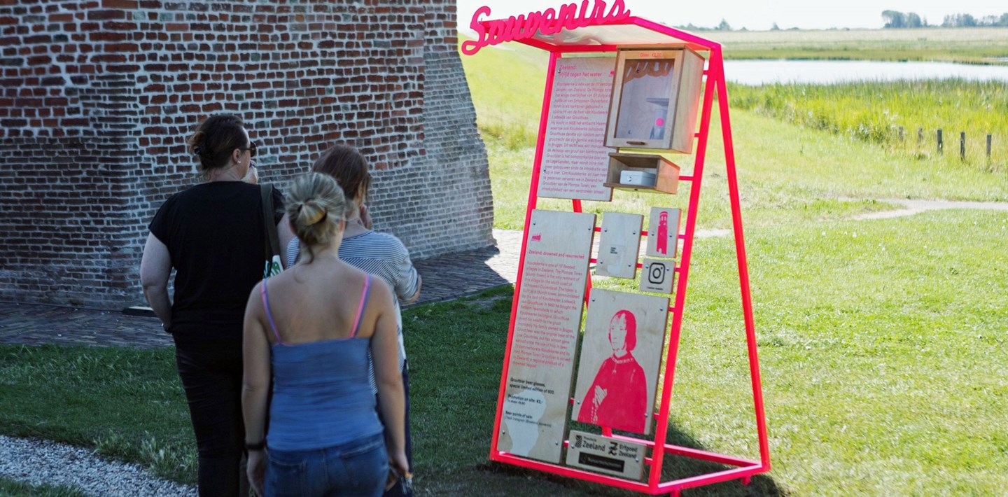 Mensen bekijken de souvenirstand van het Koudekerke gruitbier bij de Plompe Toren (foto Viorella Luciana)