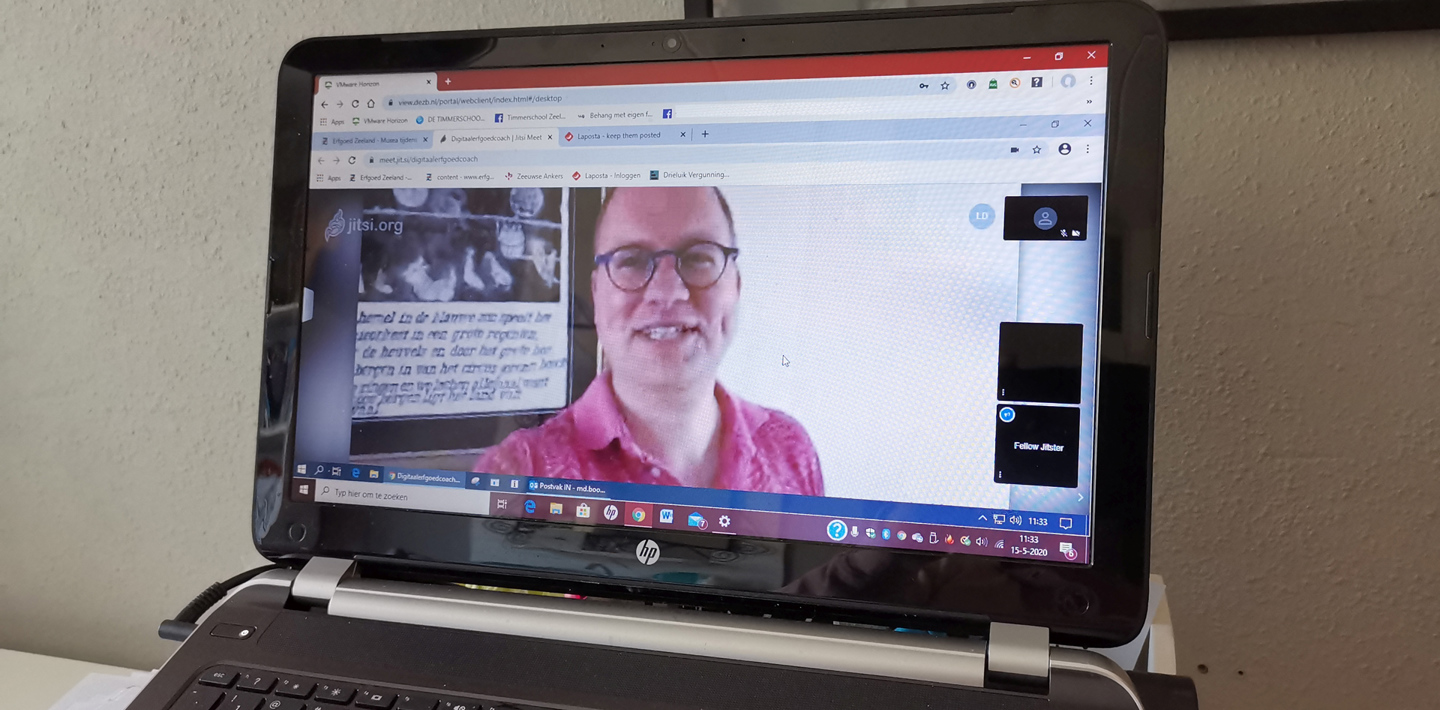 Via een laptop in gesprek zijn met de digitaal erfgoed coach tijdens zijn inloopspreekuur 