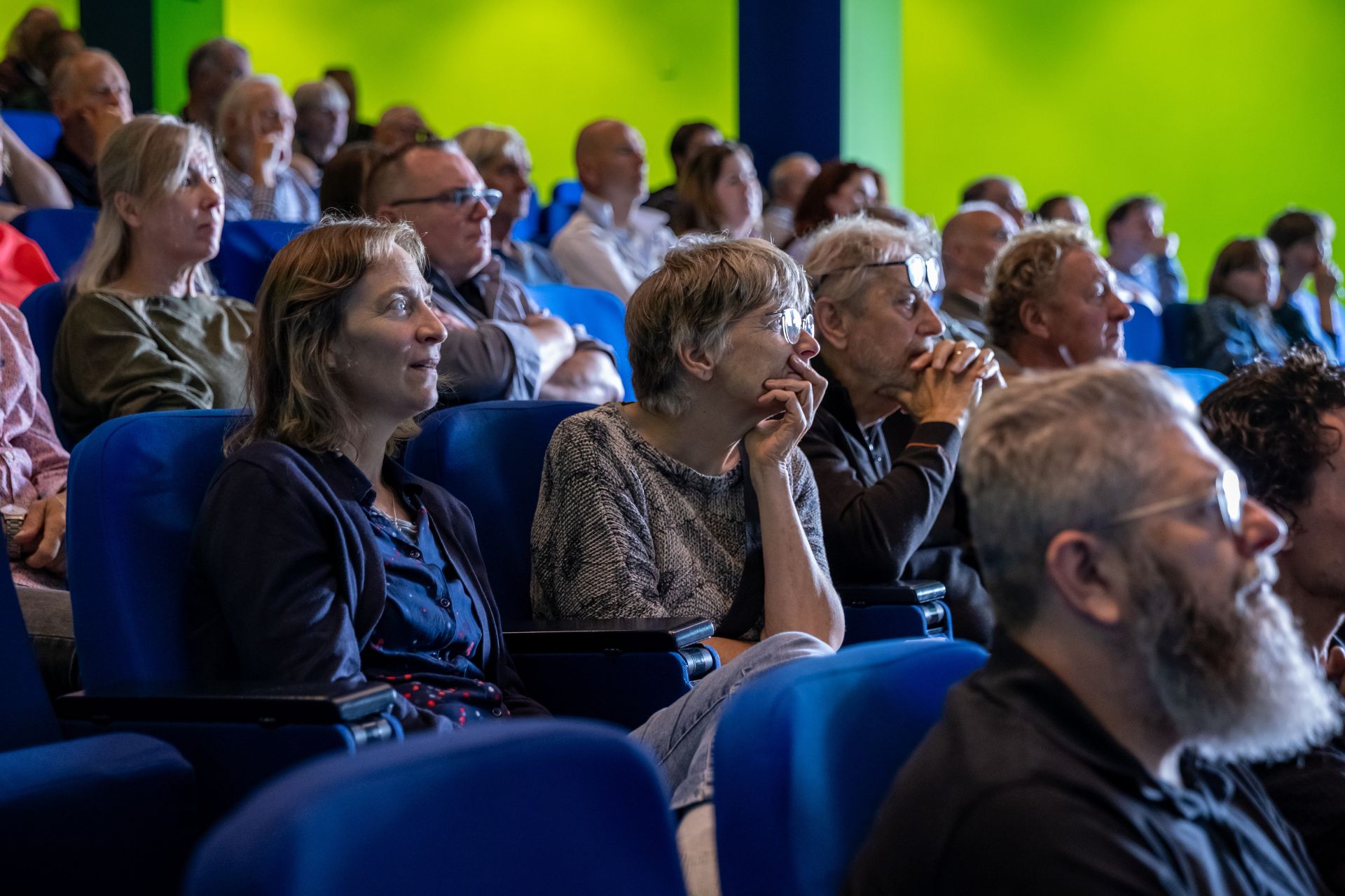 Aandachtige vrijwilligers en professionals luisteren naar de lezingen.