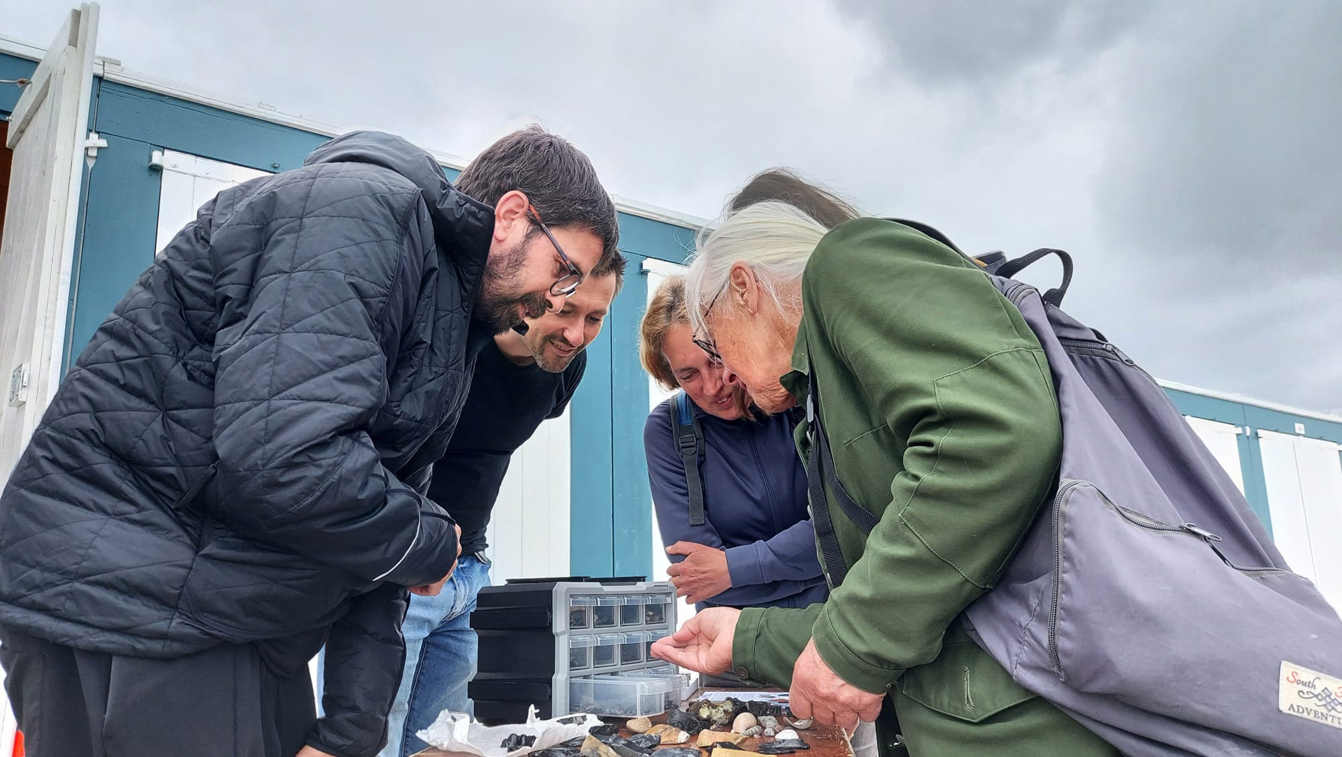 Voorbijgangers bewonderen de fossielen die uitgestald op tafel liggen.