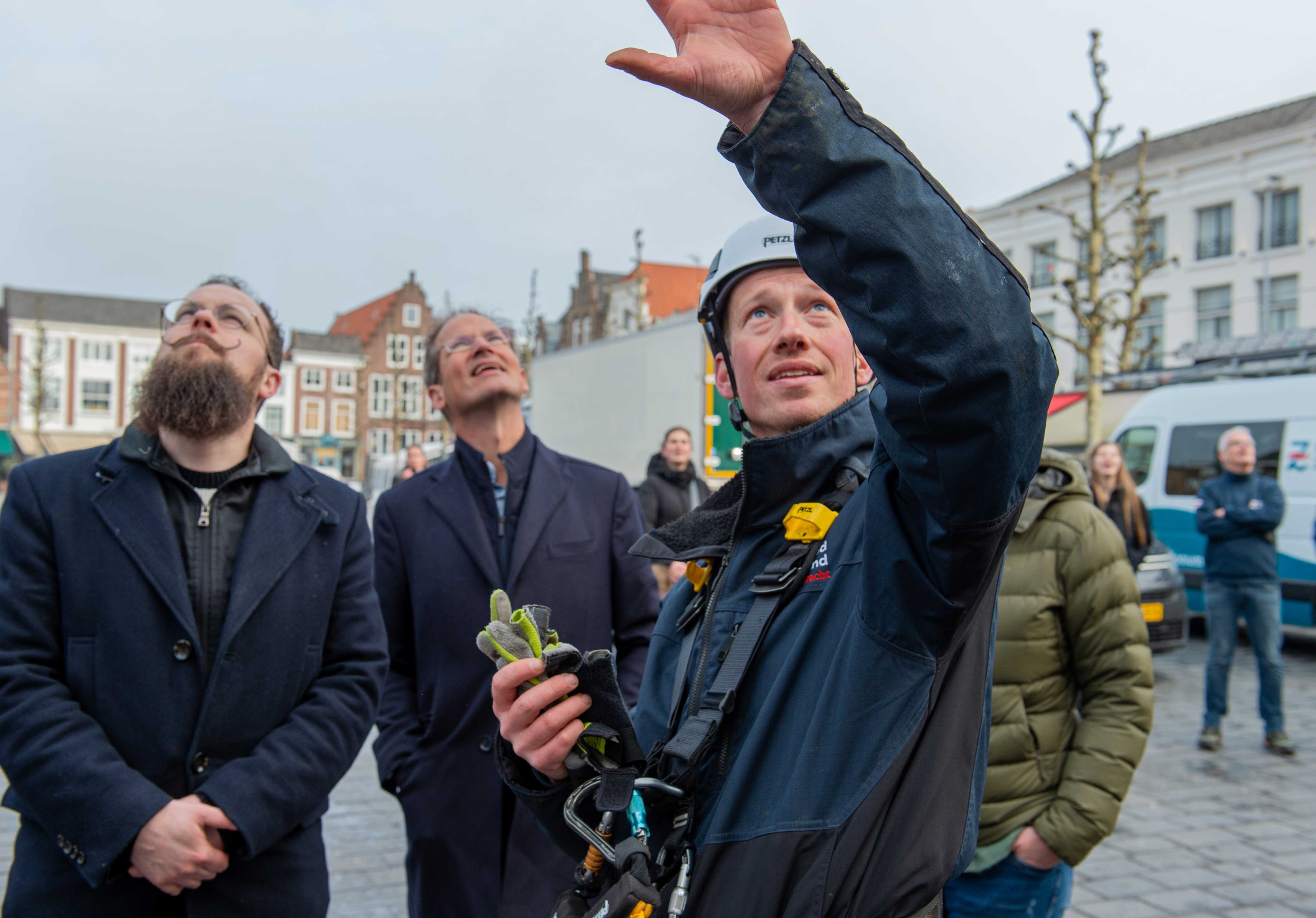 Cultuurwethouder Martijn Vermeulen, voorzitter raad van toezicht Kees-Jan Dosker en monumentenwachter Leon Leendertse volgen het uitrollen van de banner.