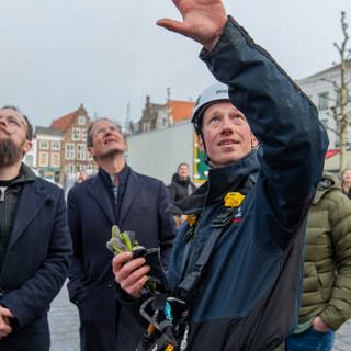 Cultuurwethouder Martijn Vermeulen, voorzitter raad van toezicht Kees-Jan Dosker en monumentenwachter Leon Leendertse volgen het uitrollen van de banner.