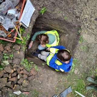 Twee jonge archeologen voor één dag onderzoeken scherven in een profielput.