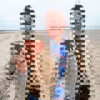 Een student van de UCR vindt een scherf op het Banjaardstrand (foto Marten Klop).