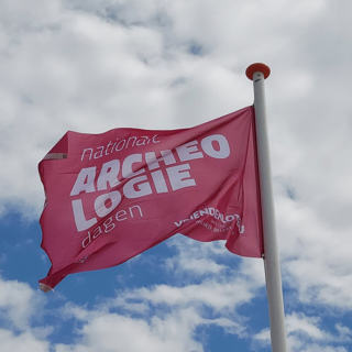 De vlag wappert op het Banjaardstrand in Kamperland tijdens de Nationale Archeologiedagen op vrijdag 14 juni.