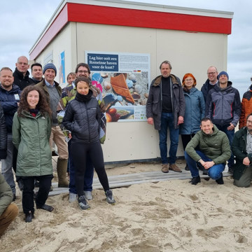 Strandzoekers, archeologen, vrijwilligers en medewerkers van Strandexploitatie Veere bij de strandpost.