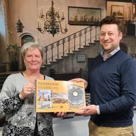 Wethouder Carla Doorn ontvangt van directeur Wilco Blaak de kerkenvisie voor de gemeente Middelburg.