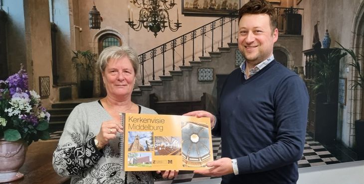 Wethouder Carla Doorn ontvangt van directeur Wilco Blaak de kerkenvisie voor de gemeente Middelburg.